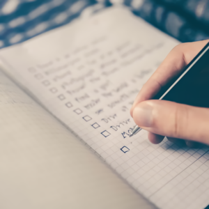 a person writing on a notebook - top 5 mistakes when hiring a home inspector